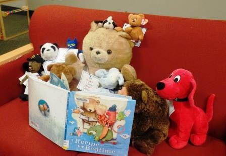 Stuffed animals, propped with a book